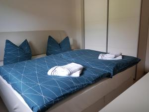 卡劳特格瑞斯赫Ferienwohnung Fischer的一张蓝色的床,配有两个白色枕头和镜子