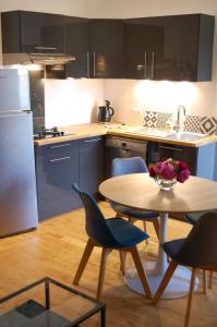 La RochettePETIT GITE EN BRACONNE的一间带桌椅的厨房和一间带冰箱的厨房