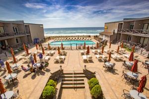 蒙托克大西洋海滩皇家度假酒店的一个带桌椅的游泳池以及大海
