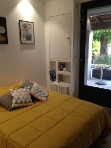 福卡尔基耶CHAMBRE CENTRE VILLE Coté soleil的一间卧室配有一张带黄色床单的床和一扇窗户。