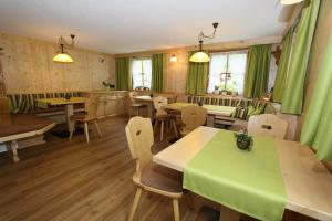 皮茨河谷圣莱昂哈德Haus Bödele的一间设有绿色窗帘和桌椅的餐厅