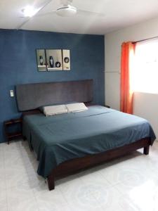 坎佩切AMBAR Rooms的一间卧室配有一张蓝色墙壁的床