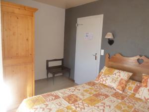 Longcochon马鞍酒店的一间卧室配有一张带木制床头板的床