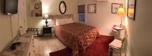 蒂尔顿蒂尔顿酒店的一间卧室配有一张红色床罩的床