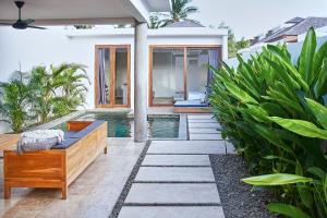 龙目岛库塔Kumbara Villas的一个带游泳池和房子的后院