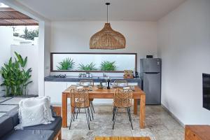 龙目岛库塔Kumbara Villas的厨房以及带桌椅的用餐室。