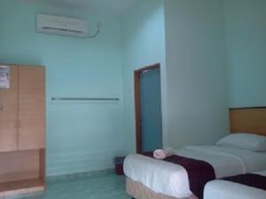 瓜埠玫瑰因汽车旅馆的一间卧室设有两张床和蓝色的墙壁