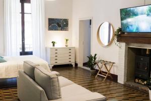 萨尔泰阿诺CASADELCORSO NOGI的客厅配有床和壁炉上的电视