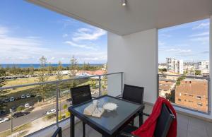 黄金海岸Ocean Pacific Resort - Official的阳台配有桌椅和大窗户。