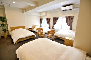 泉佐野KURA HOTEL IZUMISANO的酒店客房配有两张床和一张书桌