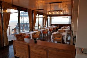 鲸湾港佩里坎波伊特酒店的用餐室设有桌椅和窗户。