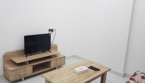 杜科姆Duqm Suites的客厅配有木桌上的电视