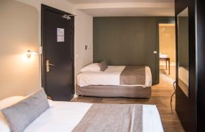 托农莱班红色伯爵酒店的一间卧室设有两张床,一扇门通往房间