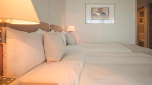 加拉班格兰德瑞奥塞班度假村的配有白色枕头的酒店客房内的两张床