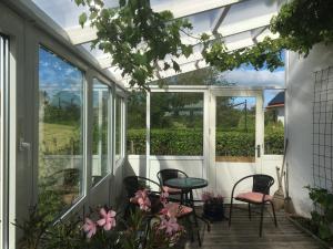 FarsøMargretelyst的一个带桌椅和窗户的温室