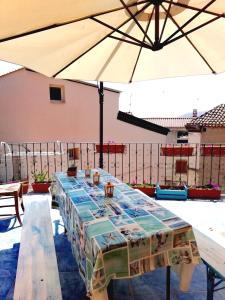 LoceriCasa di Eugenia的露台上配有带遮阳伞的大桌子