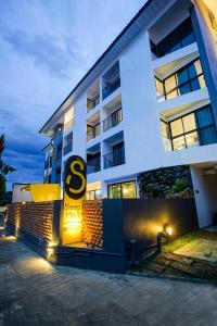 清迈Sleep Mai Thapae Chiang Mai Old City Lifestyle Hotel - SHA Plus的白色的建筑,上面有大标志