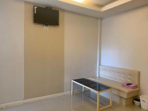 Ban Khlong Ta KhotMerry Resort Photaram的一间设有桌子和墙上电视的房间