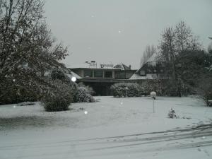 Garlasco迪亚曼蒂I酒店的雪覆盖的院子,背景是房子