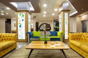 韦林格勒巴尔尼奥Spa水疗酒店的客厅配有黄色和蓝色的沙发和桌子