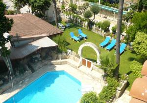 利马索尔绿地乡村俱乐部公寓的享有带躺椅的庭院游泳池的顶部景致