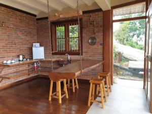 KadugannawaThe Cloud Resort的厨房设有砖墙和木桌