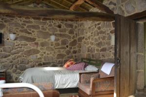 阿尔库什迪瓦尔德维什Penedino Mountain Cottage的卧室配有一张石墙床