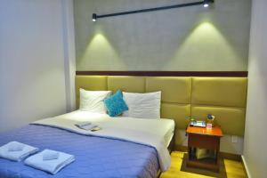 胡志明市Giang Son Hotel 江山民宿胡志明市的一间卧室配有一张带蓝色和白色床单的床。