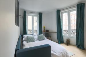 巴黎LE MATISSIA的一间卧室配有一张带绿色窗帘的床和窗户。