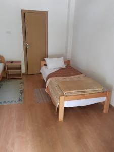 利塔尼Sobe Gmitrovic的一间卧室配有一张床,铺有木地板