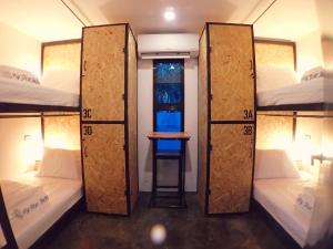 莫阿尔博阿Pig Dive Hostel Moalboal的客房设有三张双层床,配有桌子