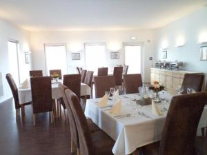 弗伦登贝格达斯纽公园酒店的用餐室配有桌椅和白色桌布