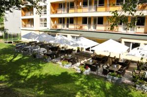 瓦赫河畔比斯特里察Hotel Garni的享有酒店空中美景,配有桌子和遮阳伞