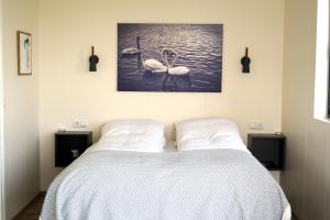 劳加尔瓦特恩Austurey Cottages的一间卧室,配有一张水中两个天鹅的床