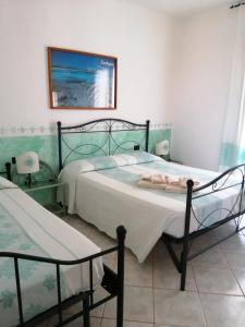 圣特奥多罗Hotel Il Platano的卧室配有两张床,墙上挂着一幅画
