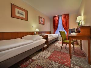 布拉格布拉格城堡杰利尼杜尔EA酒店的酒店客房配有两张床和一张书桌