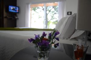 新帕尔米拉波萨达埃尔纳奇柔尔酒店的花瓶,花朵紫色,坐在桌子上