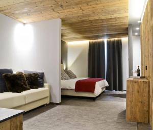 博尔米奥Hotel san Vitale的一间卧室配有一张床和一个沙发
