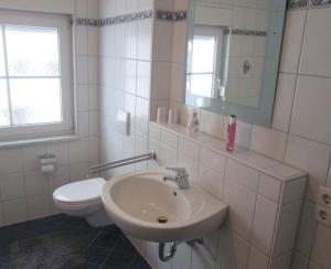 阿尔戈伊地区伊斯尼Ferienwohnung Steible的白色的浴室设有水槽和卫生间。