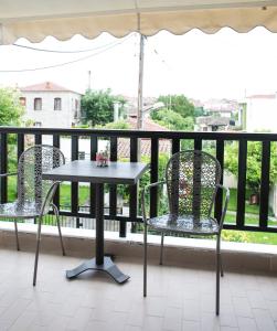 阿菲托斯Yannis Apartments的阳台配有一张桌子和两把椅子