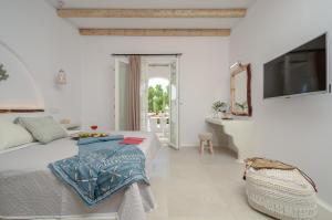 阿吉奥斯普罗科皮奥斯Naxos Nature Suites的一间白色卧室,配有床和电视