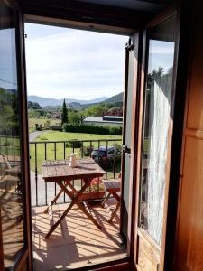BusturiaEcoHotel Rural Angiz的露台的滑动玻璃门享有美景,配有桌子。