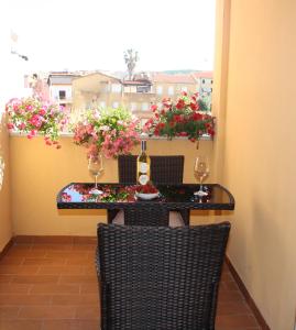 阿尔盖罗Appartamenti Sole 1的鲜花阳台的桌椅