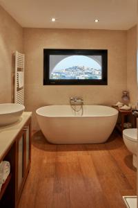 Puig D’en VallsBab el Oued Villa Ibiza的一间带浴缸和两个盥洗盆的浴室以及一台电视。