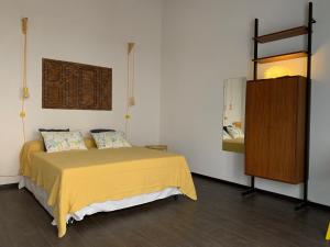 锡拉库扎Casa VerbaVolant的一间卧室配有黄色的床和木制橱柜