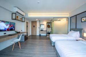 Ban Phraek SaMayson Place Hotel的酒店客房设有两张床和一台平面电视。