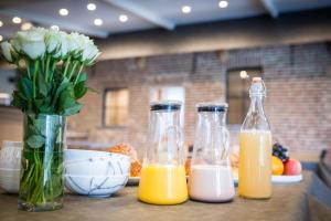 HoogledeB&B Gitsdal的三瓶橙汁和一瓶鲜花