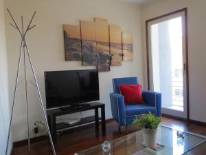 马托西纽什Porto 2 Bedroom Beach Apartment的客厅配有电视和蓝椅