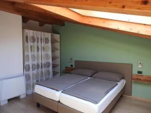 马尔切西内Appartamenti Tasel with heated Pool的一间卧室设有一张床和木制天花板