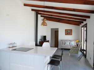 El Pinar del HierroCasa Viges的厨房以及带白色墙壁和木制天花板的客厅。